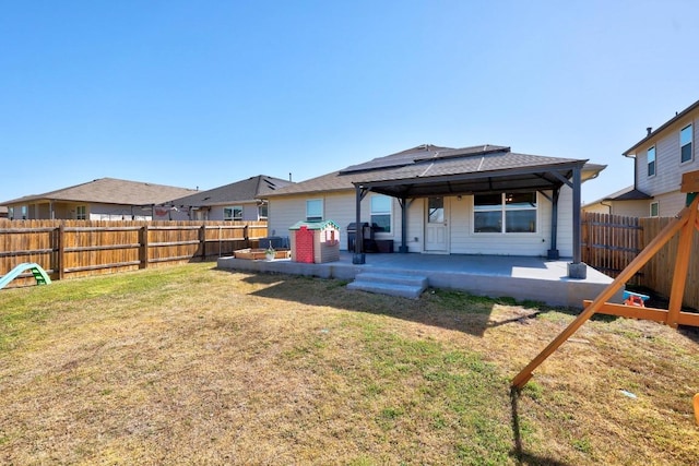 back of house featuring a patio, a yard, and a fenced backyard