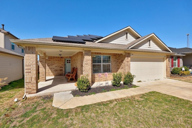 single story home featuring brick siding, roof mounted solar panels, driveway, and a garage