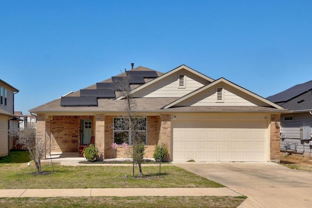 view of front of property featuring a front yard, solar panels, an attached garage, concrete driveway, and brick siding