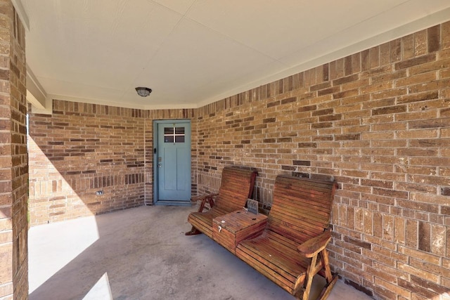 doorway to property featuring brick siding and a patio