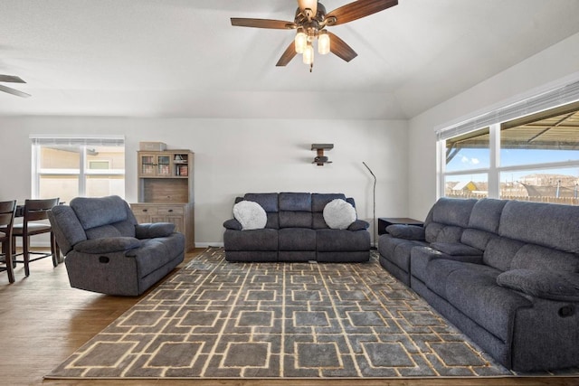 living area featuring baseboards, a ceiling fan, and wood finished floors