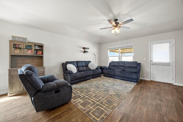 living area featuring a ceiling fan, baseboards, and light wood-type flooring