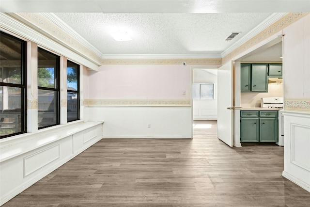 unfurnished dining area featuring visible vents, a textured ceiling, and crown molding