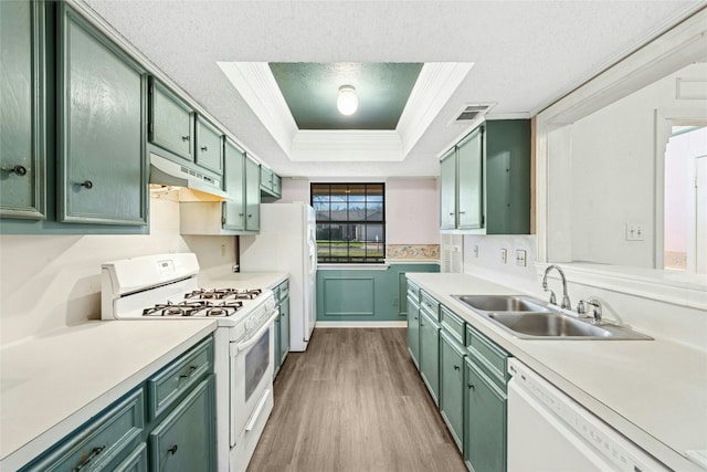 kitchen featuring a sink, under cabinet range hood, white appliances, green cabinets, and a raised ceiling