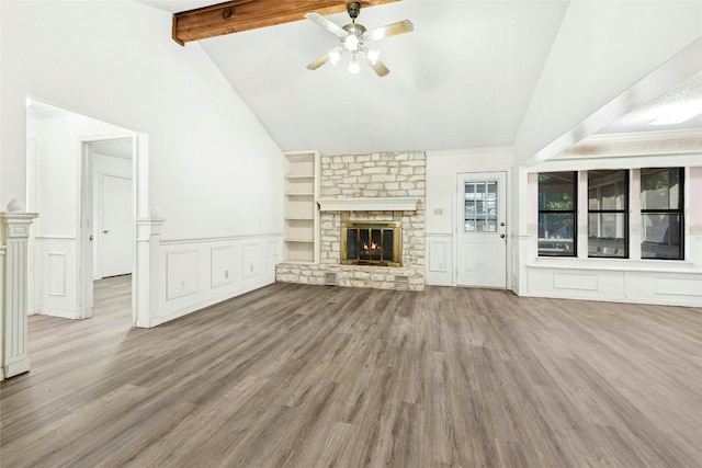 unfurnished living room featuring ceiling fan, vaulted ceiling with beams, wood finished floors, and a fireplace