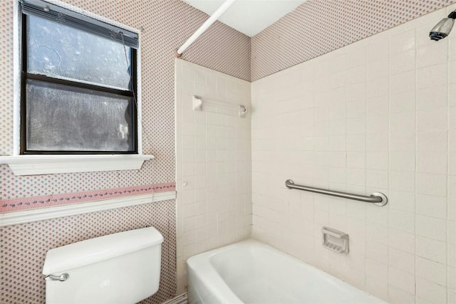 full bath with a wainscoted wall, toilet, tub / shower combination, and wallpapered walls