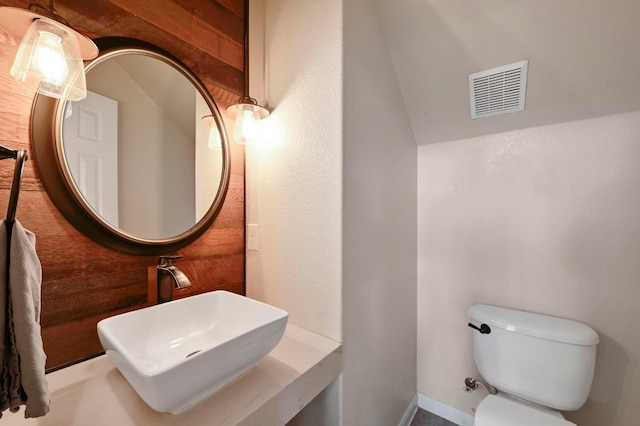 bathroom featuring toilet, visible vents, and a sink