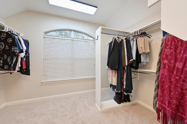 walk in closet featuring lofted ceiling with skylight and carpet floors