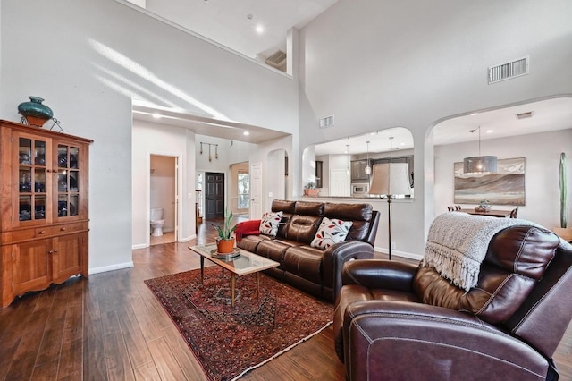 living area featuring dark wood-type flooring, baseboards, and visible vents