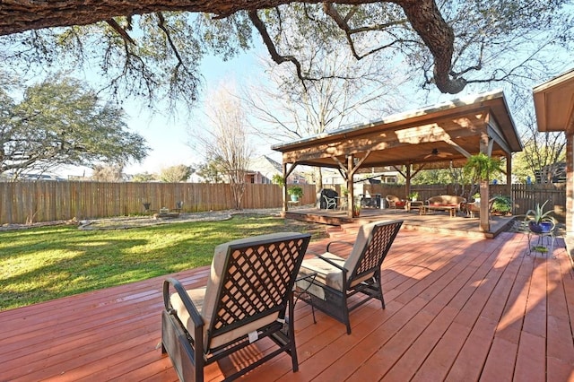 wooden deck featuring a gazebo, a yard, a fenced backyard, and ceiling fan