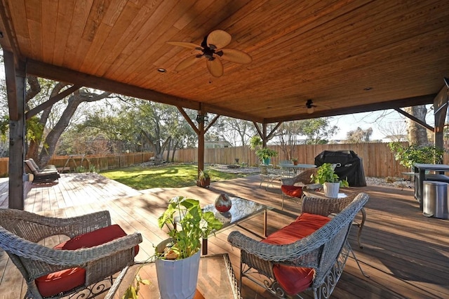 wooden terrace featuring outdoor dining space, a fenced backyard, a grill, outdoor lounge area, and ceiling fan