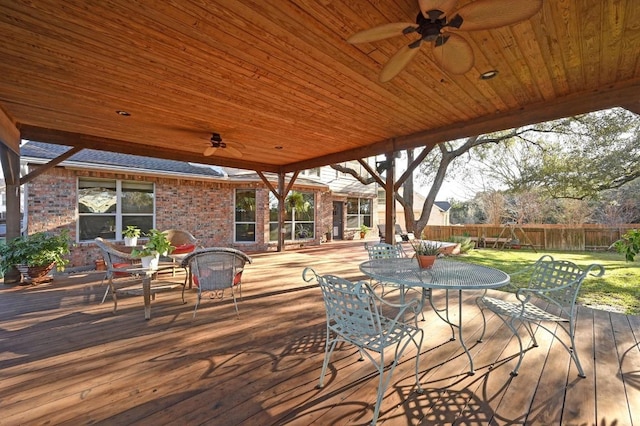 deck with outdoor dining space, ceiling fan, and fence