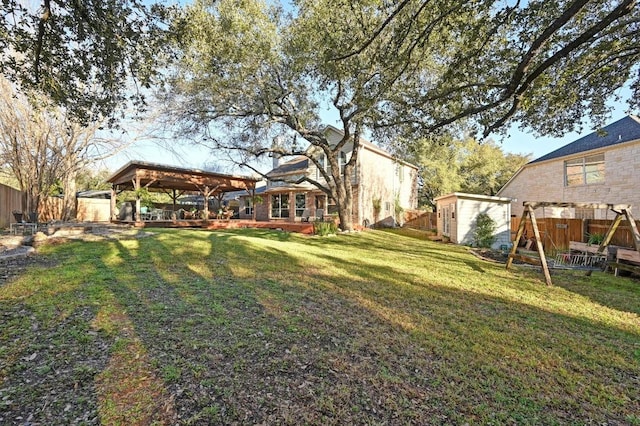 view of yard featuring a gazebo, a fenced backyard, a storage shed, and an outdoor structure