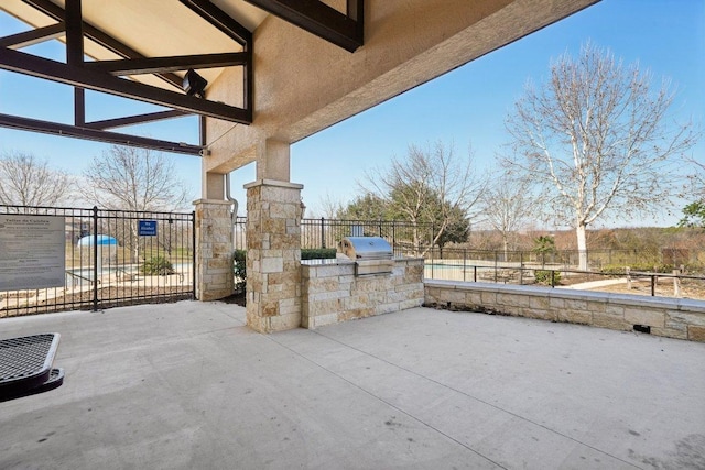 view of patio with grilling area, exterior kitchen, and fence