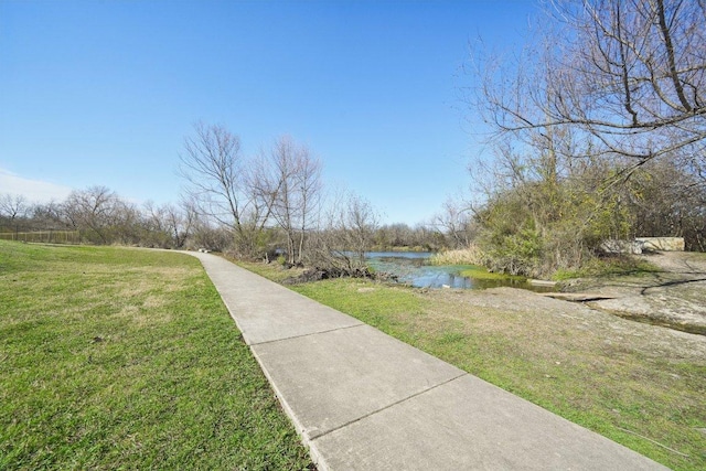 view of home's community with a yard and a water view