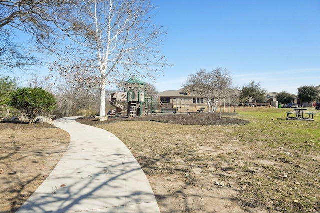 view of property's community with playground community and a lawn