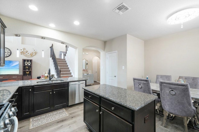 kitchen with visible vents, arched walkways, a sink, stove, and dishwasher