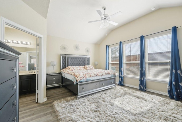 bedroom with baseboards, lofted ceiling, ensuite bathroom, wood finished floors, and a ceiling fan