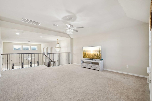 carpeted spare room featuring visible vents, baseboards, and ceiling fan with notable chandelier