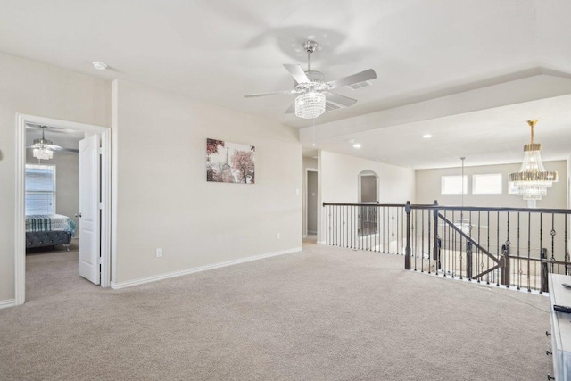 empty room featuring recessed lighting, carpet flooring, ceiling fan with notable chandelier, and baseboards