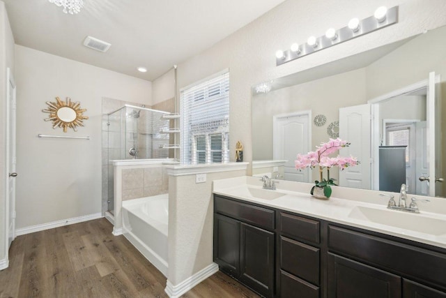 full bath with wood finished floors, visible vents, a stall shower, a sink, and a garden tub