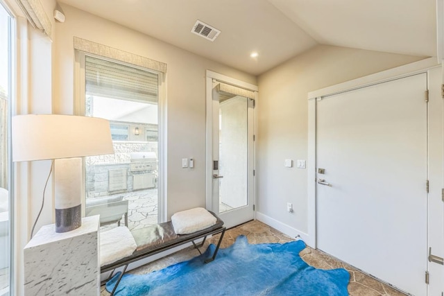 entryway featuring visible vents, baseboards, and vaulted ceiling