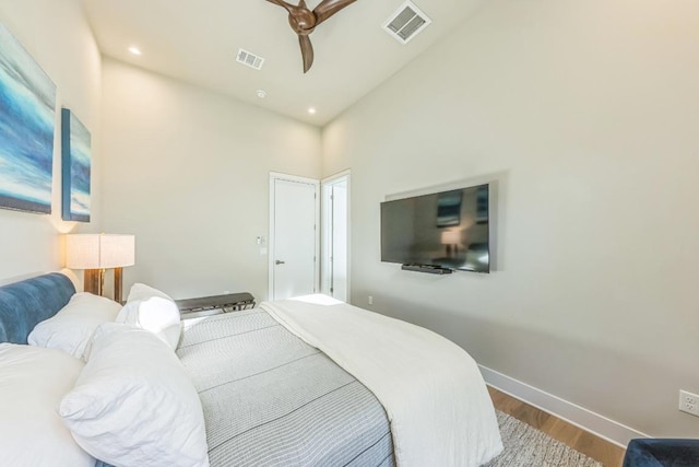 bedroom with recessed lighting, wood finished floors, visible vents, and baseboards