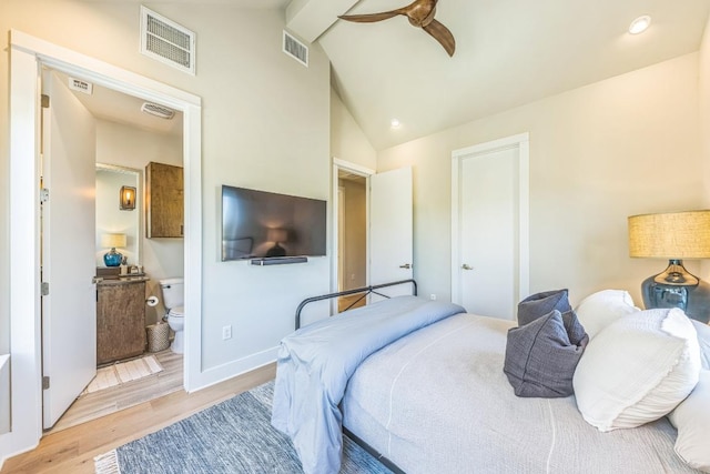 bedroom with light wood finished floors, visible vents, ensuite bathroom, and lofted ceiling with beams