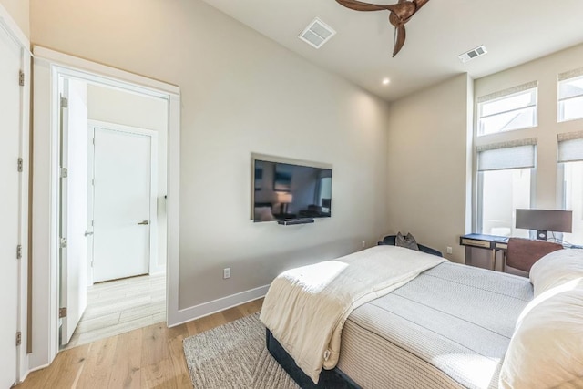 bedroom featuring baseboards, visible vents, light wood finished floors, and ceiling fan