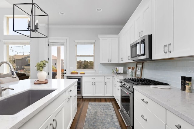 5820 Harper Park Dr Unit 70, Austin, TX 78735 - kitchen with appliances with stainless steel finishes, crown molding, beverage cooler, a chandelier, and dark wood finished floors