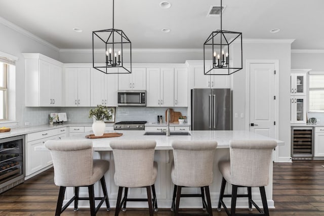 5820 Harper Park Dr Unit 70, Austin, TX 78735 - kitchen with stainless steel appliances, beverage cooler, a chandelier, ornamental molding, and recessed lighting