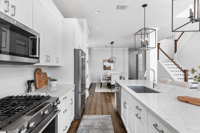 5820 Harper Park Dr Unit 70, Austin, TX 78735 - kitchen featuring appliances with stainless steel finishes, recessed lighting, backsplash, a chandelier, and light stone counters