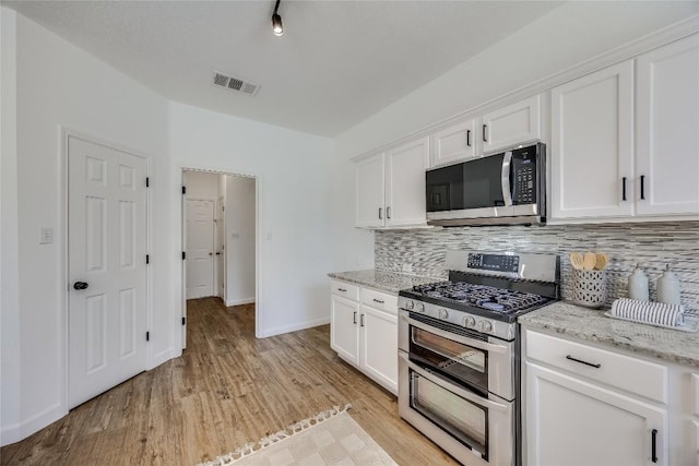 kitchen with light wood-type flooring, visible vents, backsplash, white cabinetry, and stainless steel appliances