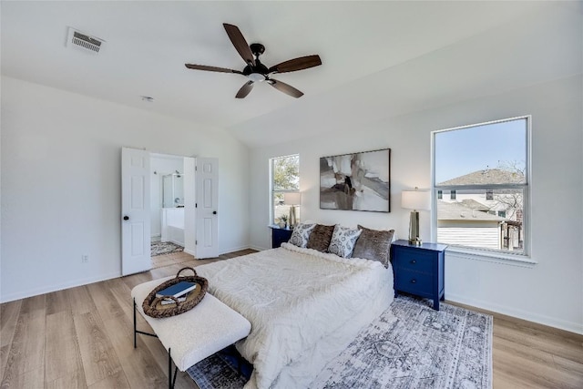 bedroom featuring vaulted ceiling, multiple windows, light wood-style floors, and visible vents