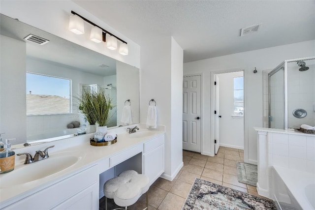 bathroom with visible vents, a stall shower, and a sink