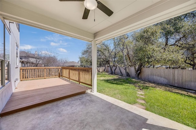 wooden deck featuring a patio area, a fenced backyard, a lawn, and ceiling fan