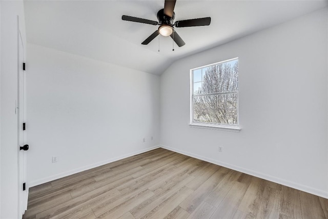 empty room with baseboards, wood finished floors, a ceiling fan, and vaulted ceiling