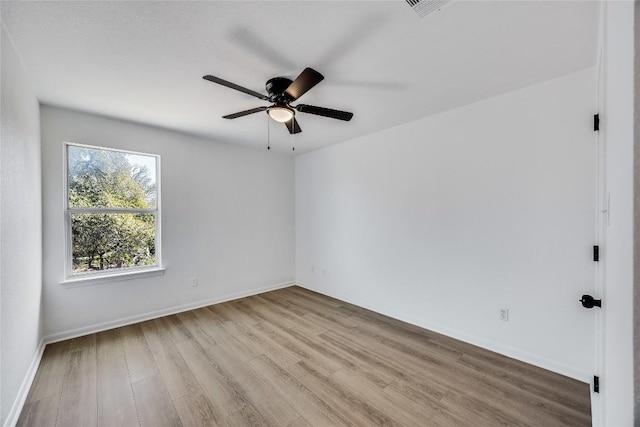 unfurnished room with visible vents, ceiling fan, baseboards, and wood finished floors