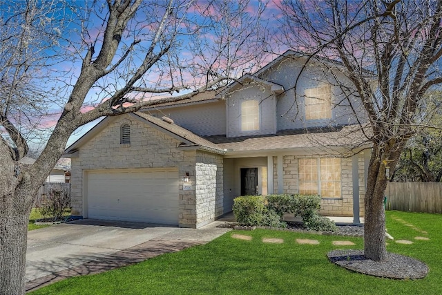 traditional home with fence, concrete driveway, a lawn, a garage, and stone siding