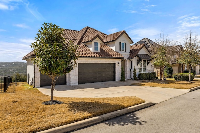 view of front facade featuring fence, stucco siding, concrete driveway, a garage, and a tile roof