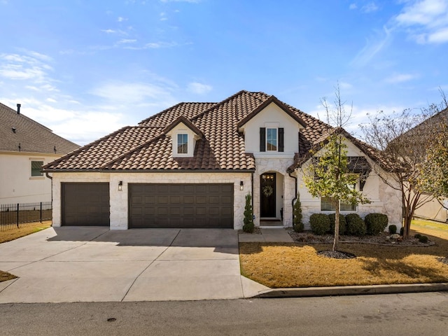 view of front facade with driveway, a tile roof, stone siding, fence, and a garage