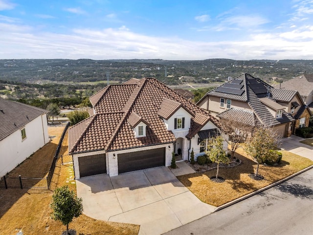 view of front facade with stucco siding, a tile roof, fence, concrete driveway, and a garage