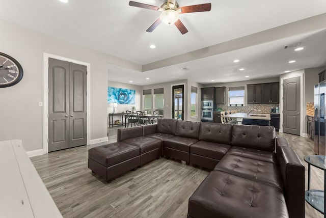 living area featuring visible vents, recessed lighting, light wood-style floors, and baseboards