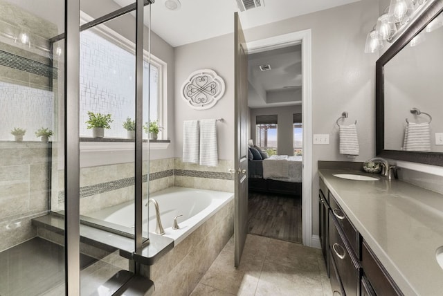 bathroom with double vanity, a stall shower, a bath, ensuite bath, and a sink