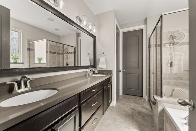 full bath with visible vents, double vanity, a stall shower, a sink, and tile patterned flooring