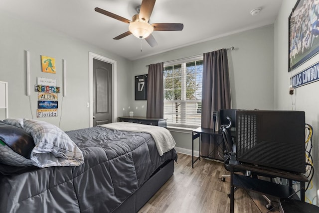 bedroom featuring a ceiling fan, wood finished floors, and baseboards