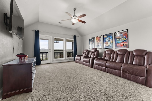 carpeted home theater room with visible vents, a ceiling fan, and lofted ceiling