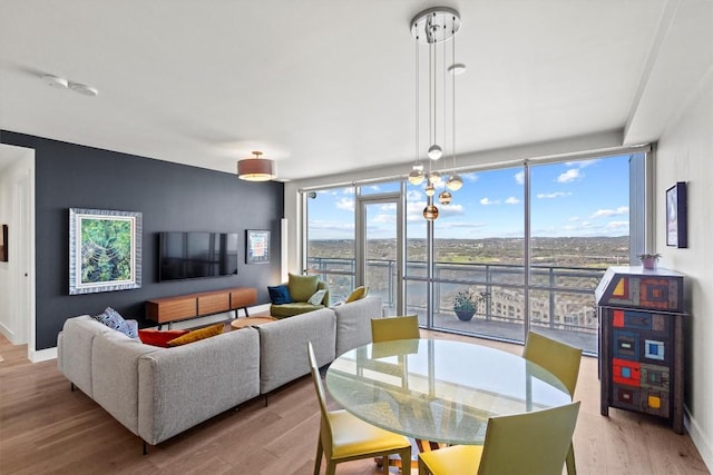 dining room with floor to ceiling windows, baseboards, and wood finished floors