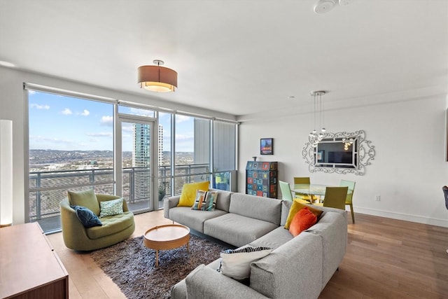 living area featuring light wood-type flooring, baseboards, and a view of city