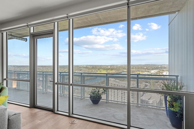 entryway featuring wood finished floors, a water view, and expansive windows